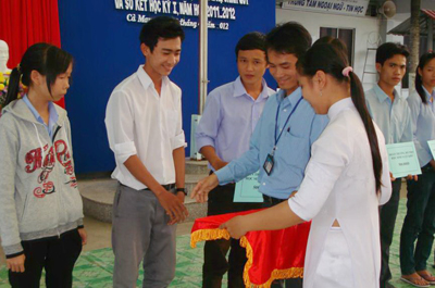 Huỳnh Chí Thảo (áo trắng) nhận học bổng do BCH Đoàn trường TC Kinh tế Kỹ thuật Cà Mau hỗ trợ cho học sinh vượt khó của trường